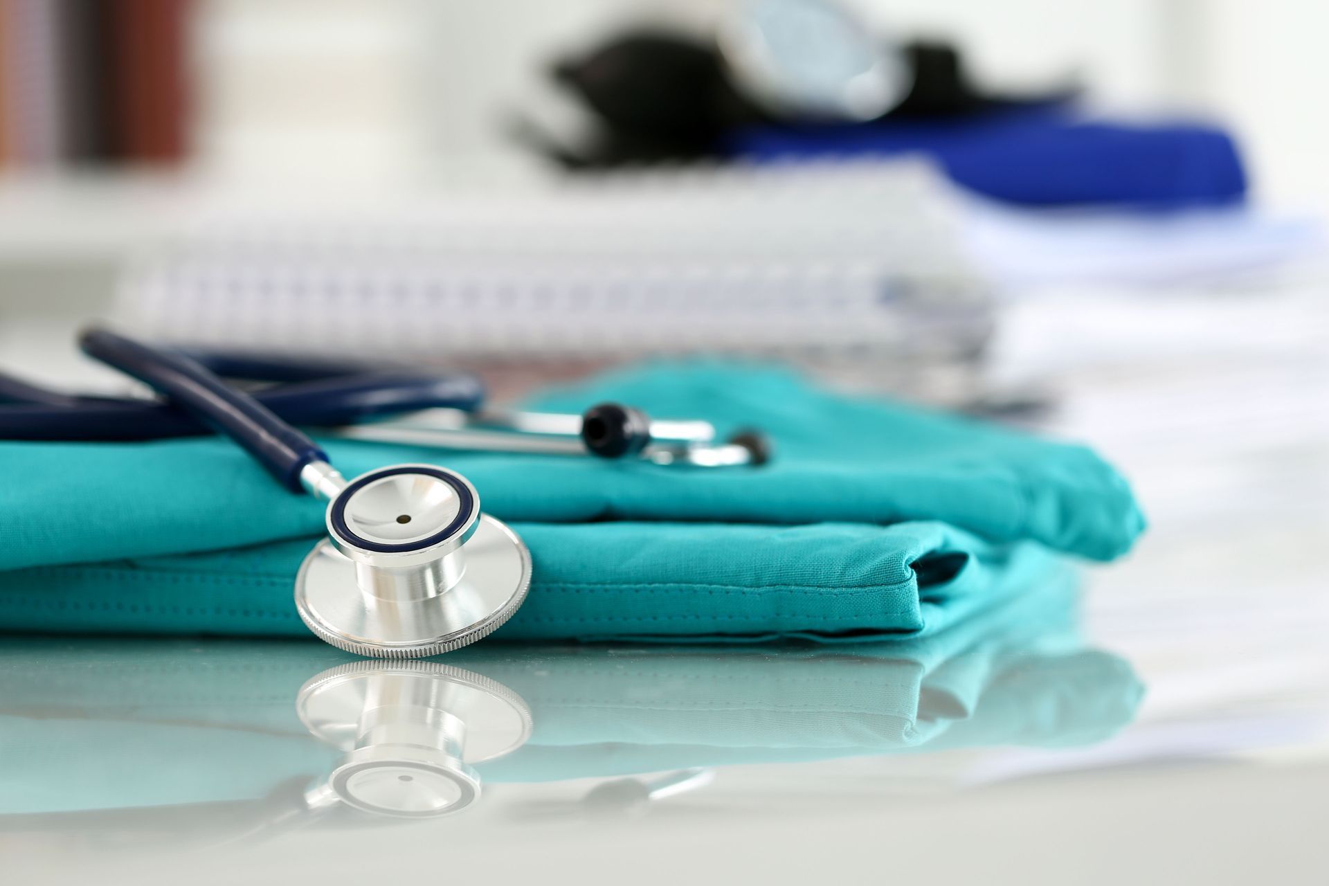 Stethoscope on folded teal fabric with a blurred medical background