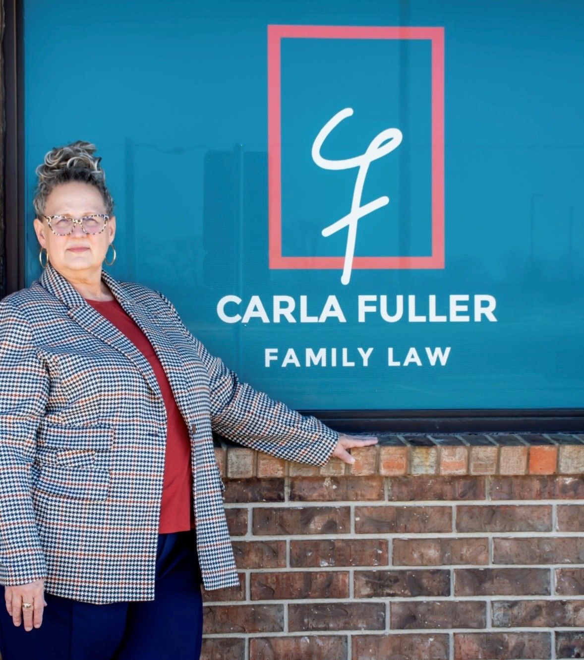 A person standing in front of a turquoise window with the sign 