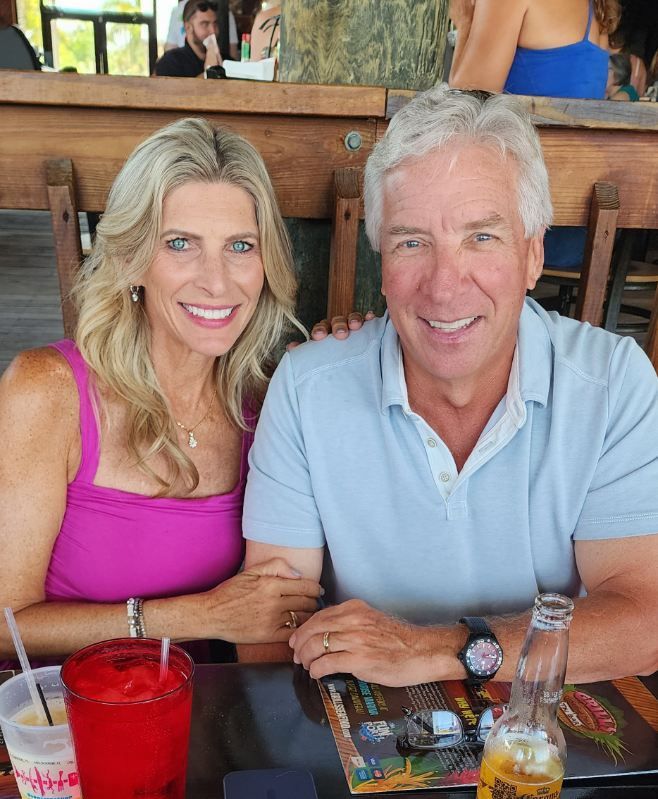 Smiling couple seated at a restaurant table with drinks in front of them.