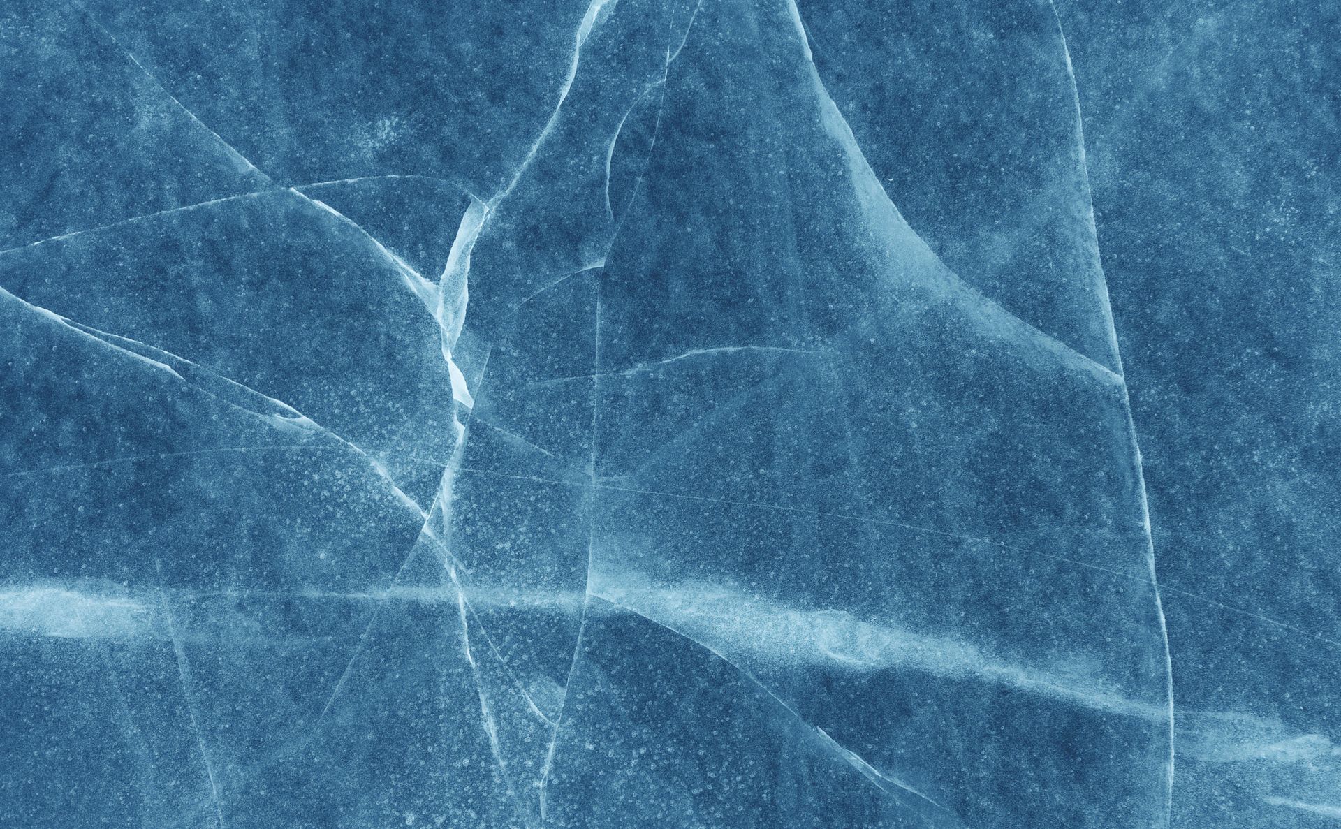 Blue cracked ice surface with white fissures and frosty texture