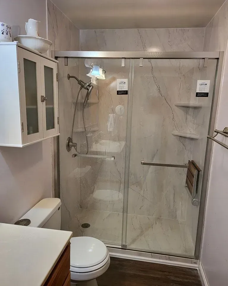 Bathroom with a glass shower, toilet, and cabinet.