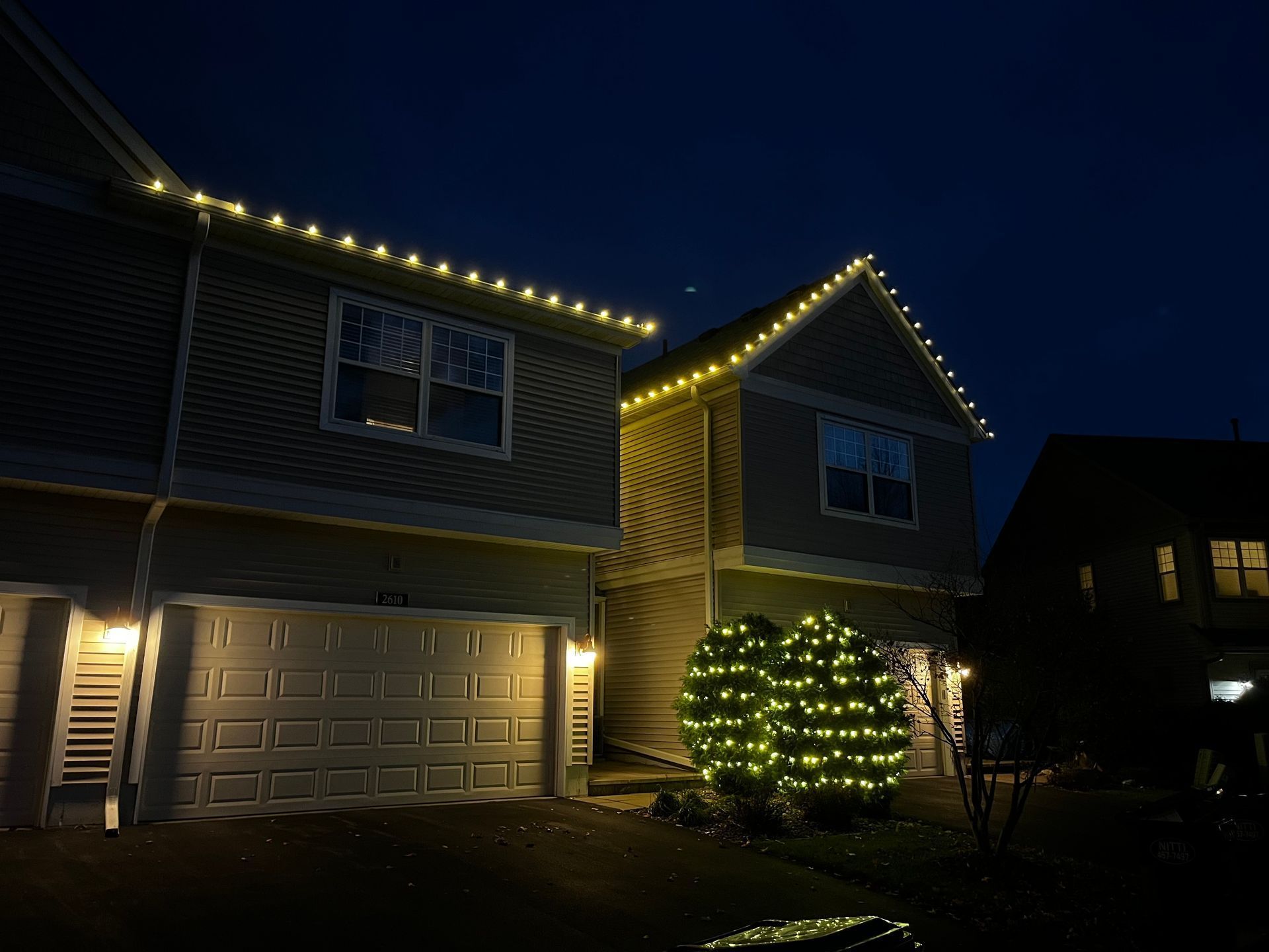 A house with Christmas lights on the roof is lit up.