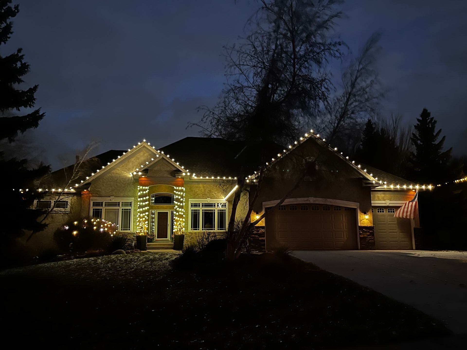 A house with Christmas lights on it is lit up at night.