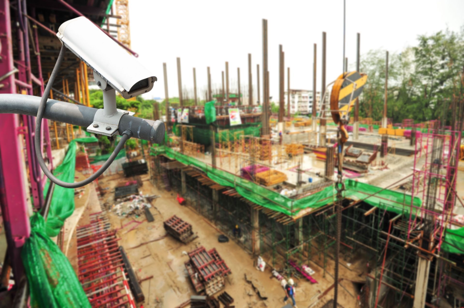 Construction site with scaffolding, concrete columns, and workers on a multi-level building frame