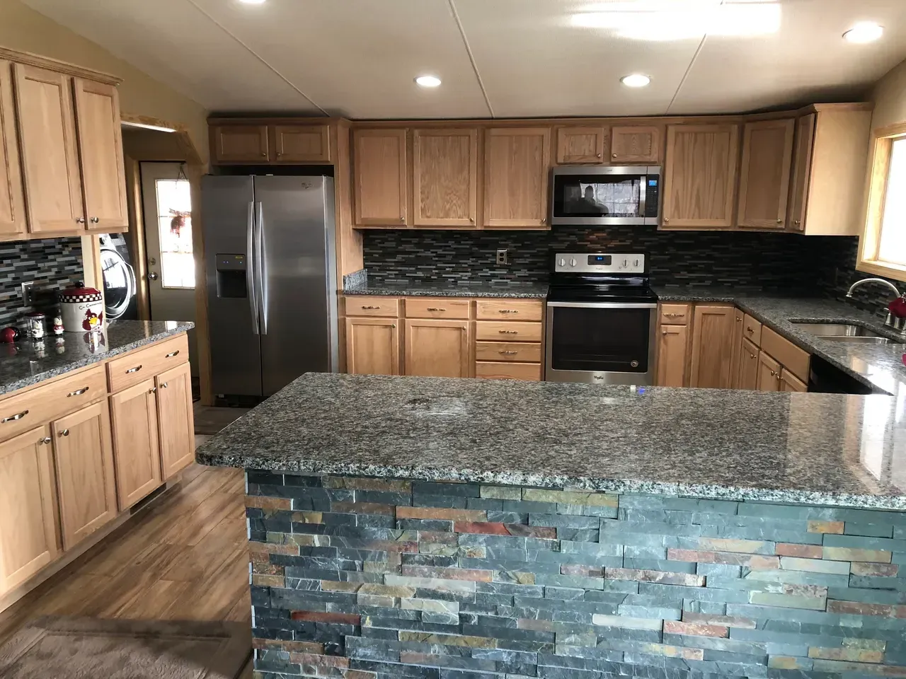 A kitchen with stainless steel appliances and granite counter tops.