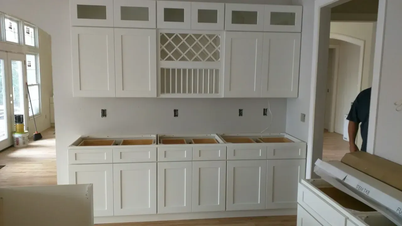 A kitchen with white cabinets and a wine rack