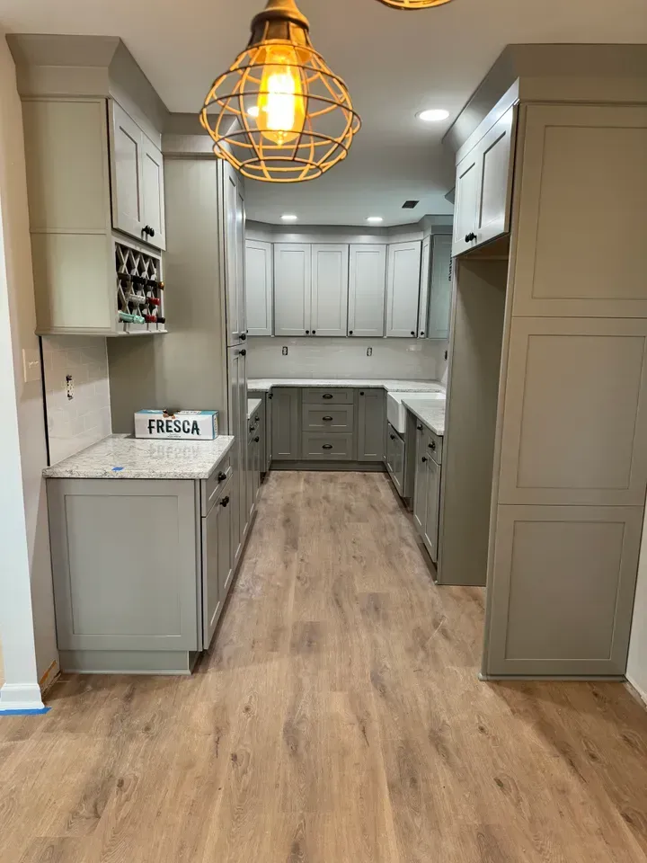 A kitchen with gray cabinets and wooden floors is being remodeled.