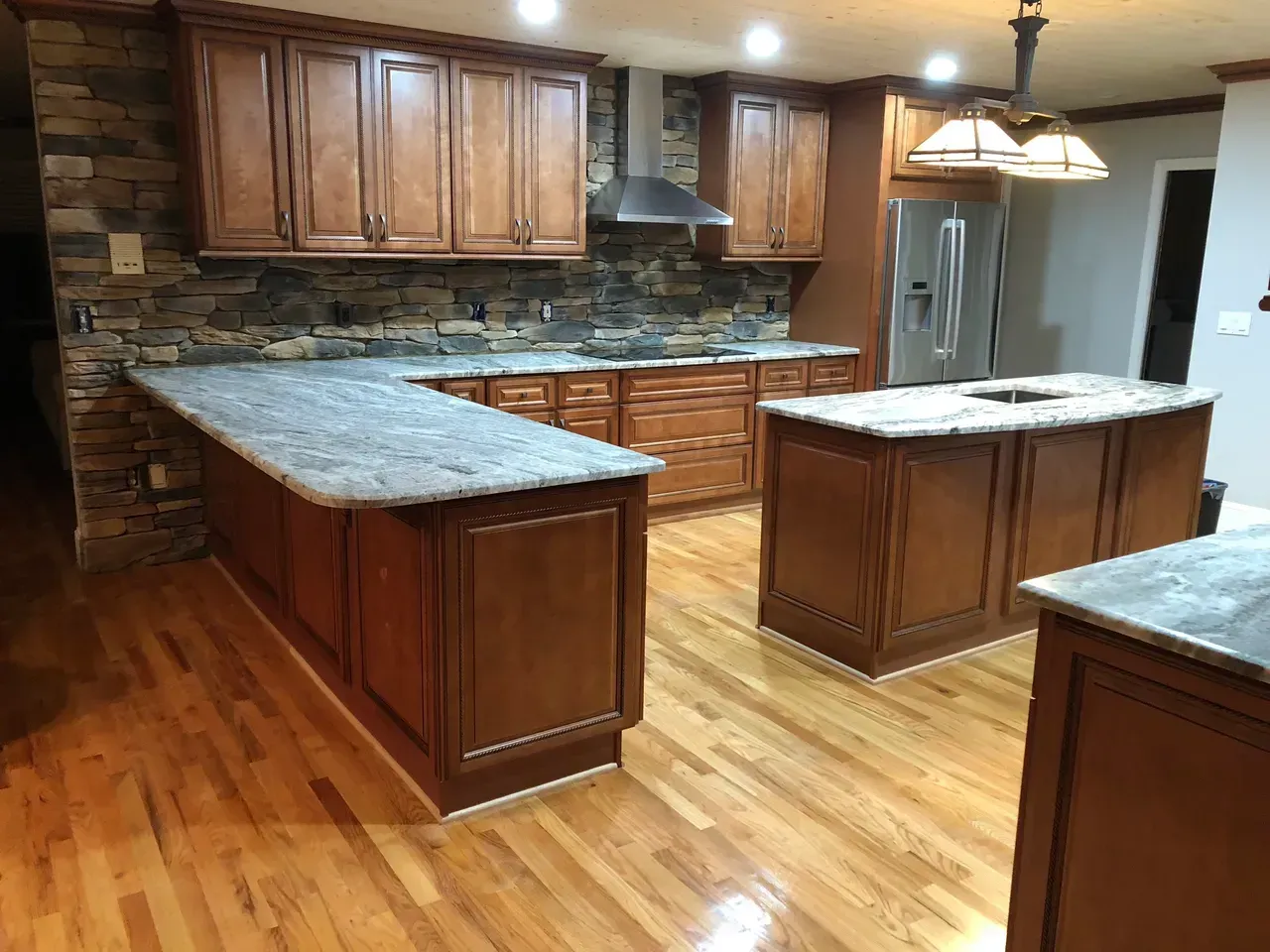 A kitchen with wooden cabinets and granite counter tops.