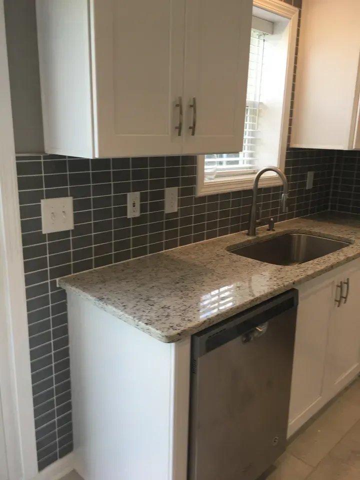 A kitchen with a sink , dishwasher and cabinets