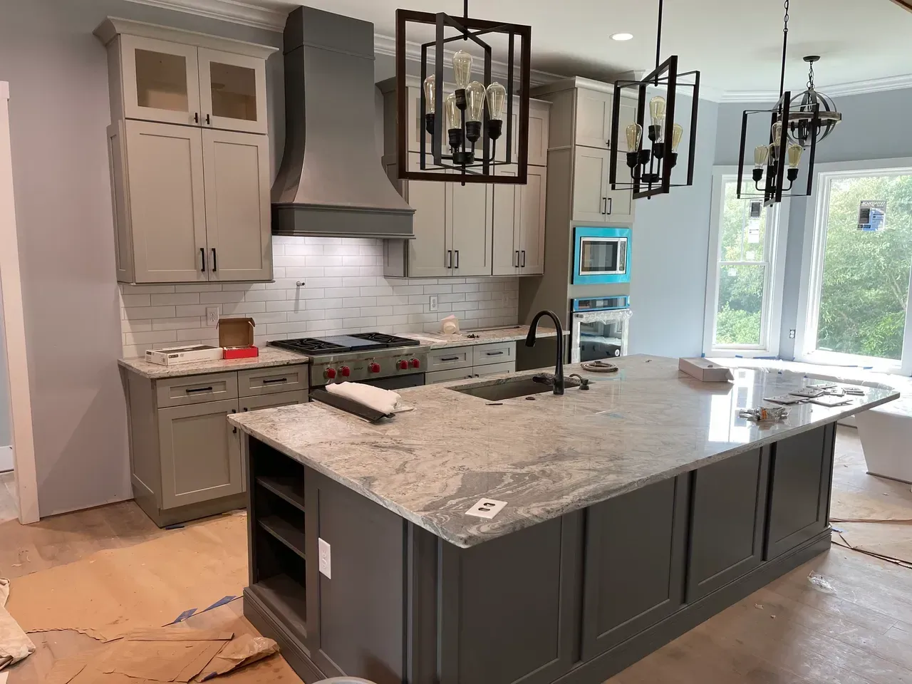 A kitchen with gray cabinets and granite counter tops is being remodeled.