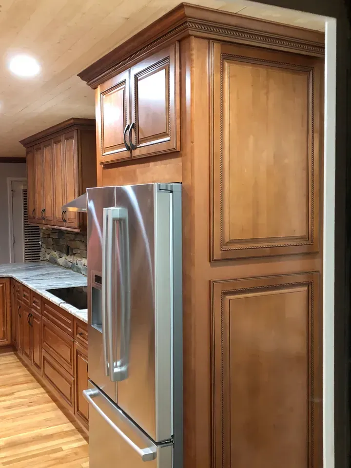 A kitchen with stainless steel appliances and wooden cabinets.