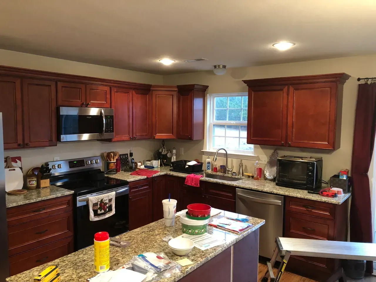 A kitchen with stainless steel appliances , granite counter tops , and wooden cabinets.