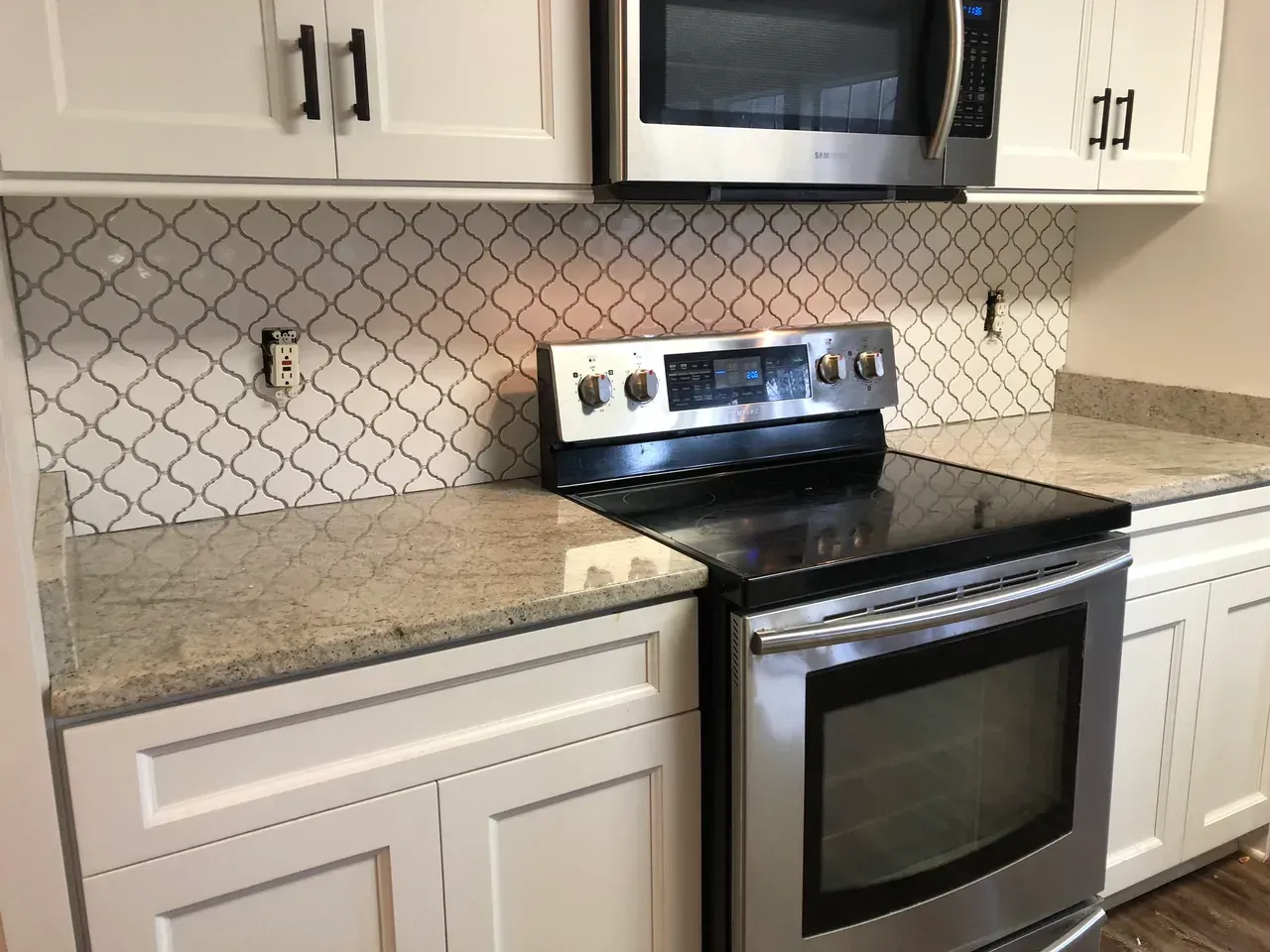 A kitchen with stainless steel appliances and white cabinets