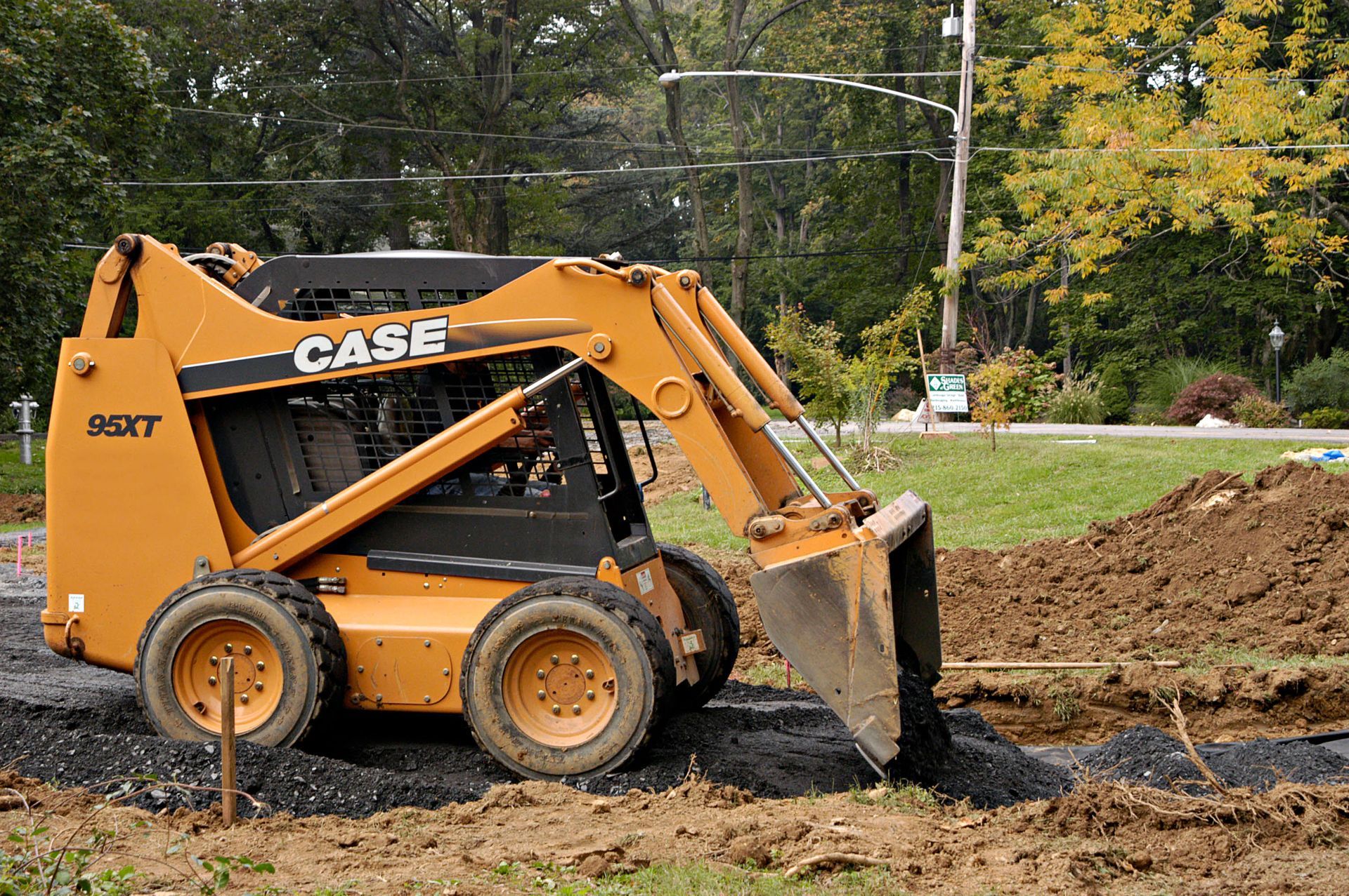 A case skid steer is digging a hole in the dirt.
