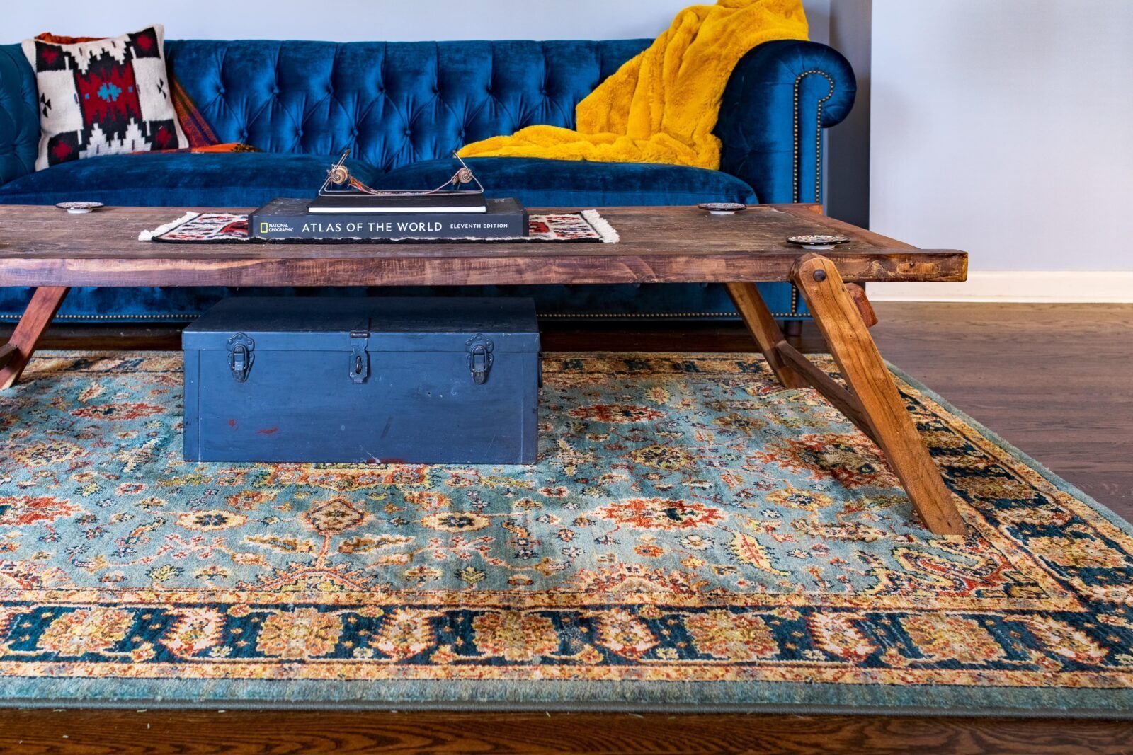 A living room with a blue couch and a wooden coffee table.