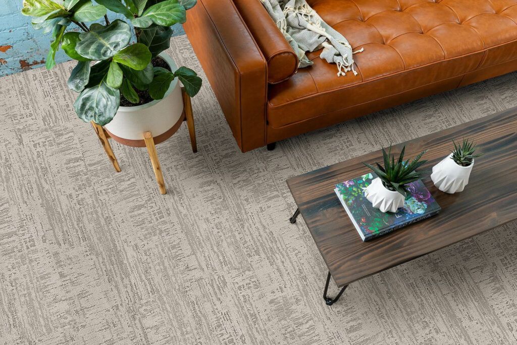 A living room with a couch , coffee table , and potted plants.