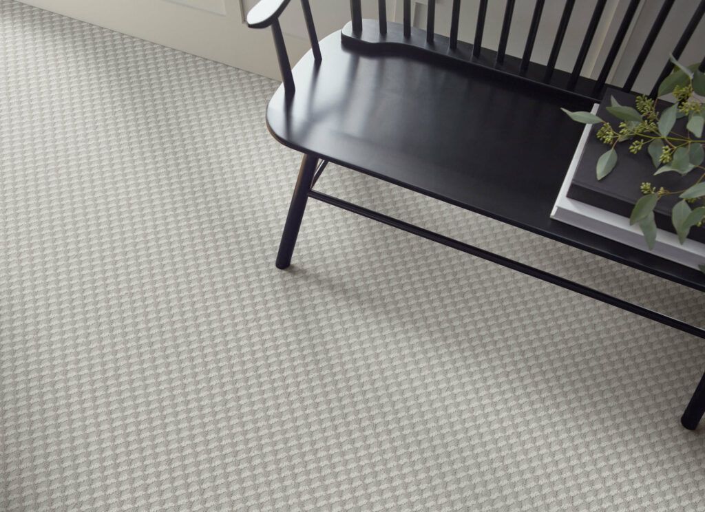 A black bench is sitting on a carpeted floor next to a book.