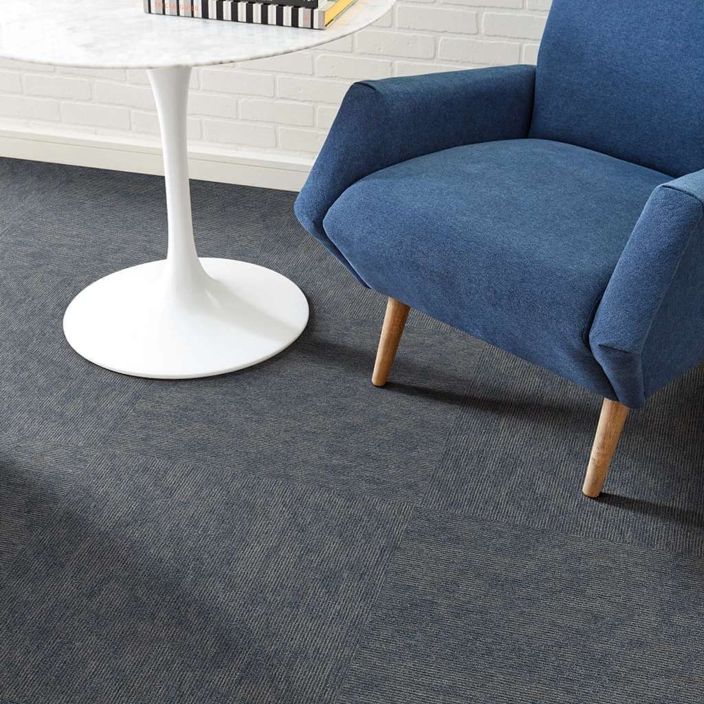 A blue chair is sitting next to a white table