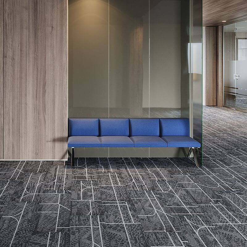 A blue couch is sitting in a waiting room next to a glass wall.