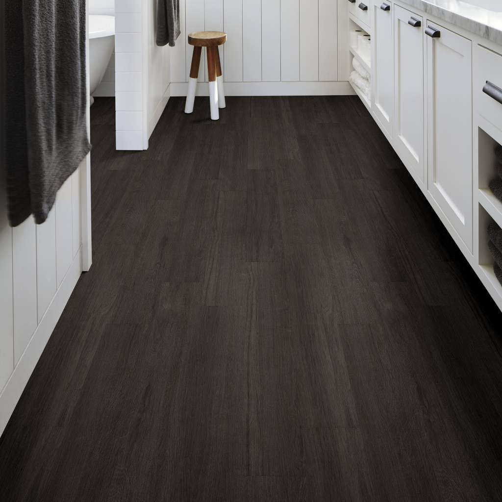 A bathroom with dark wood floors and white cabinets