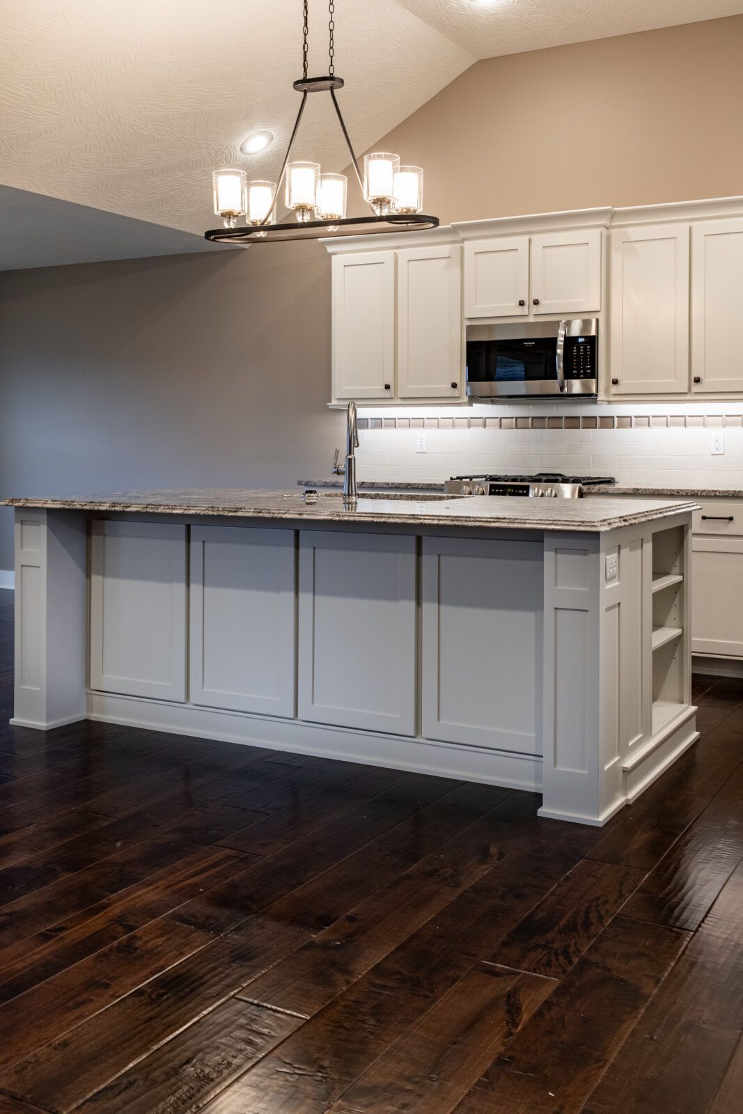 A kitchen with white cabinets and a large island in the middle.
