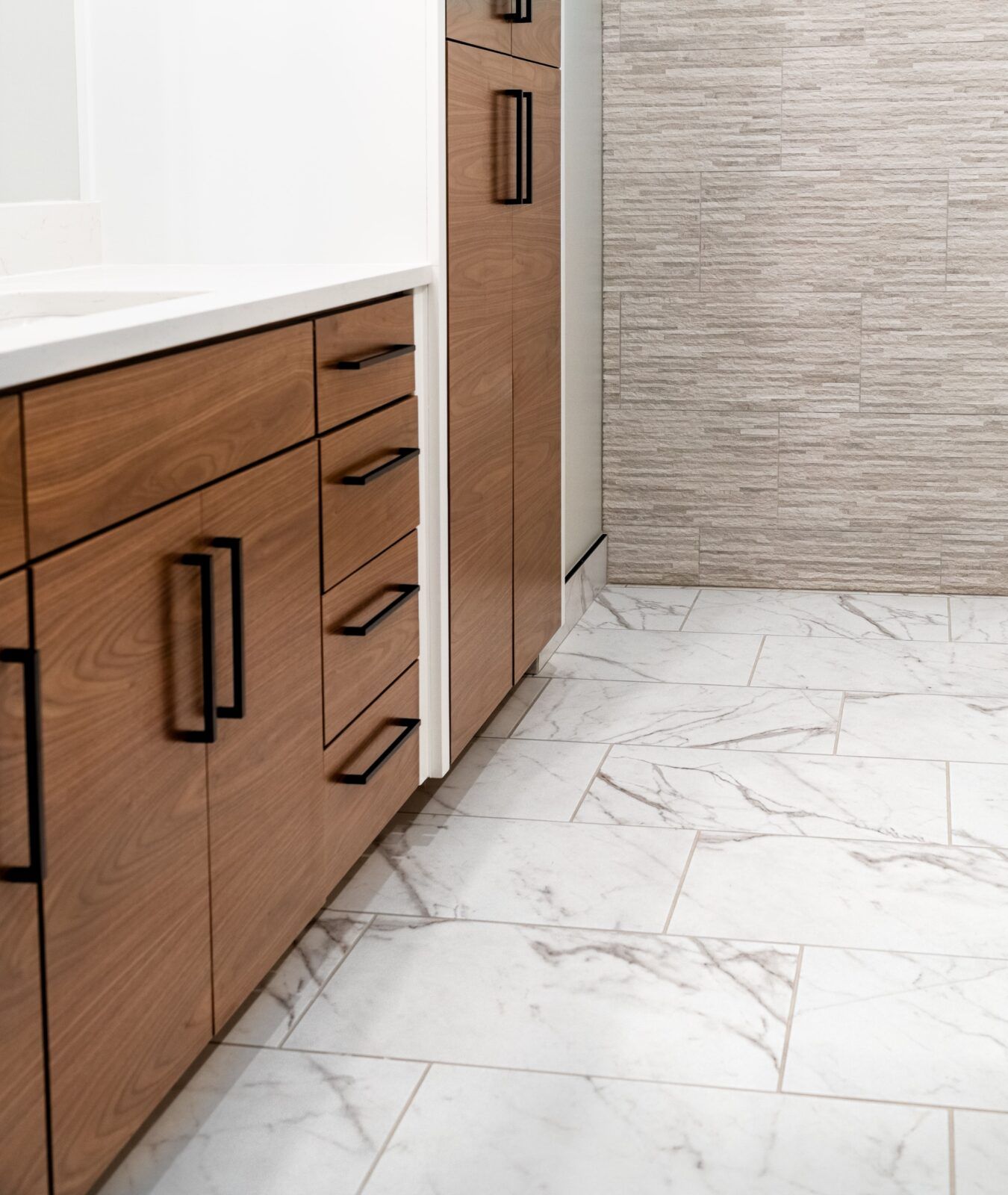 A bathroom with marble floors and wooden cabinets