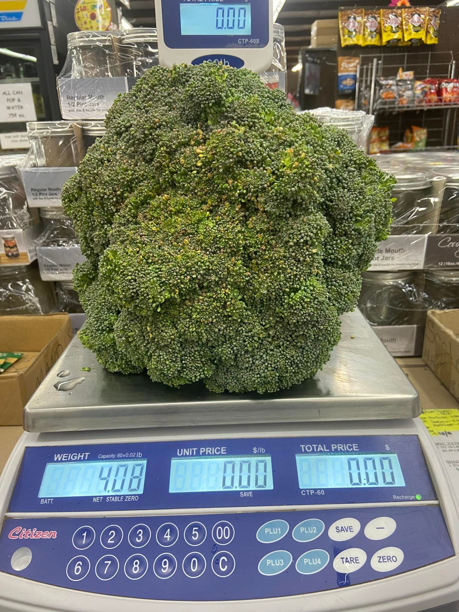 Broccoli on a digital scale weighing 4.08. Supermarket setting.