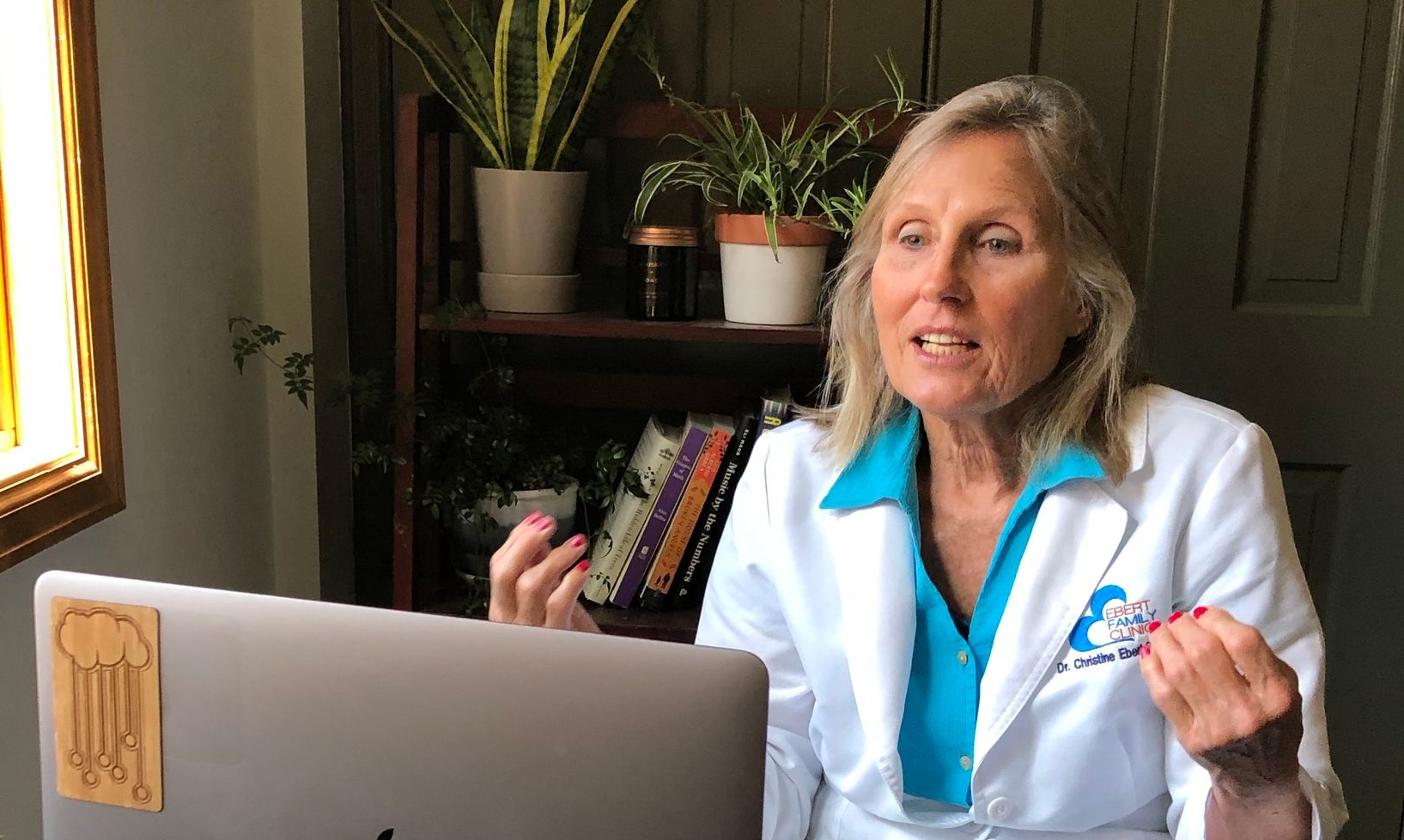 Doctor using a tablet for a telehealth consultation. The screen shows a patient, and medical data.