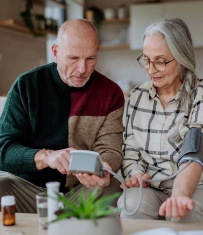 Senior couple checking blood pressure at home