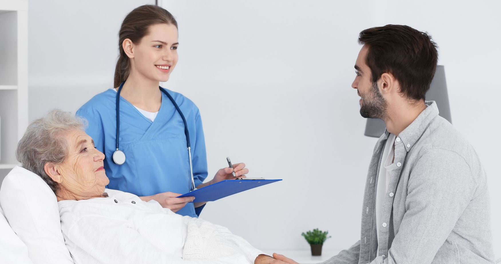 Nurse, patient in bed, and man in room
