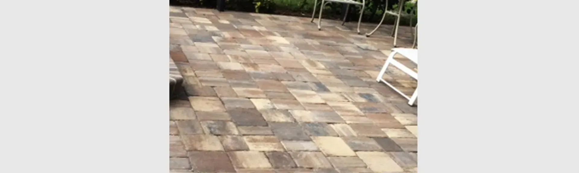 A brick patio with chairs and tables on it.