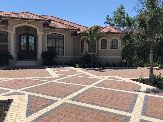 A large house with a brick driveway in front of it