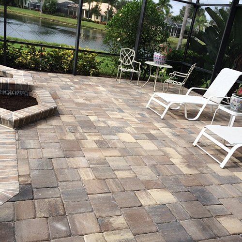 A patio with a fire pit , chairs , and a table.