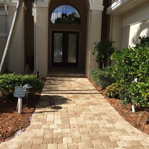 A brick walkway leading to the front door of a house
