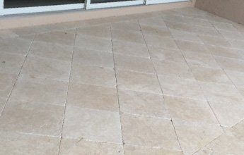 A tiled floor with a sliding glass door in the background.