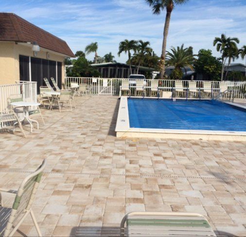 A large swimming pool surrounded by chairs and tables