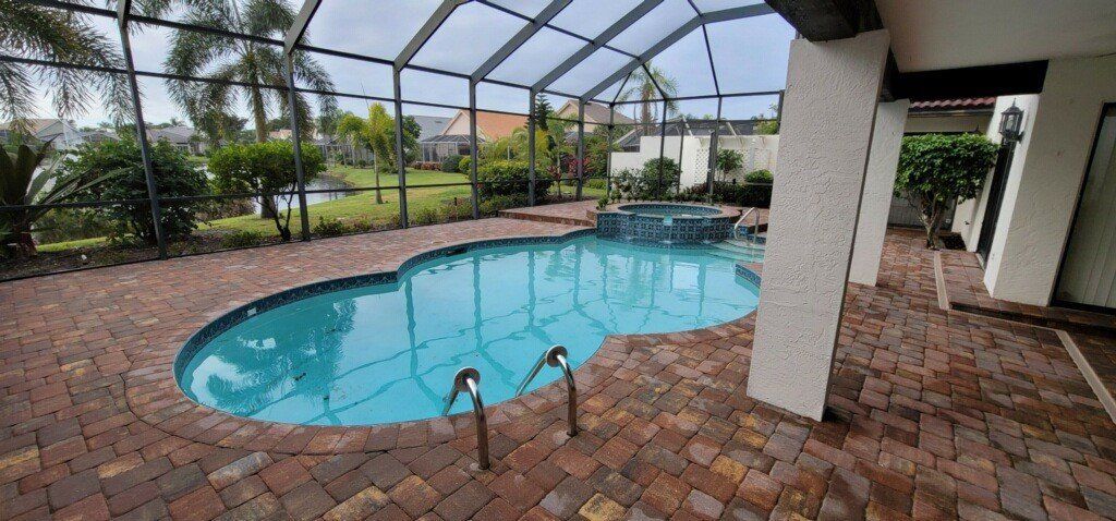 There is a large swimming pool in the backyard of a house.