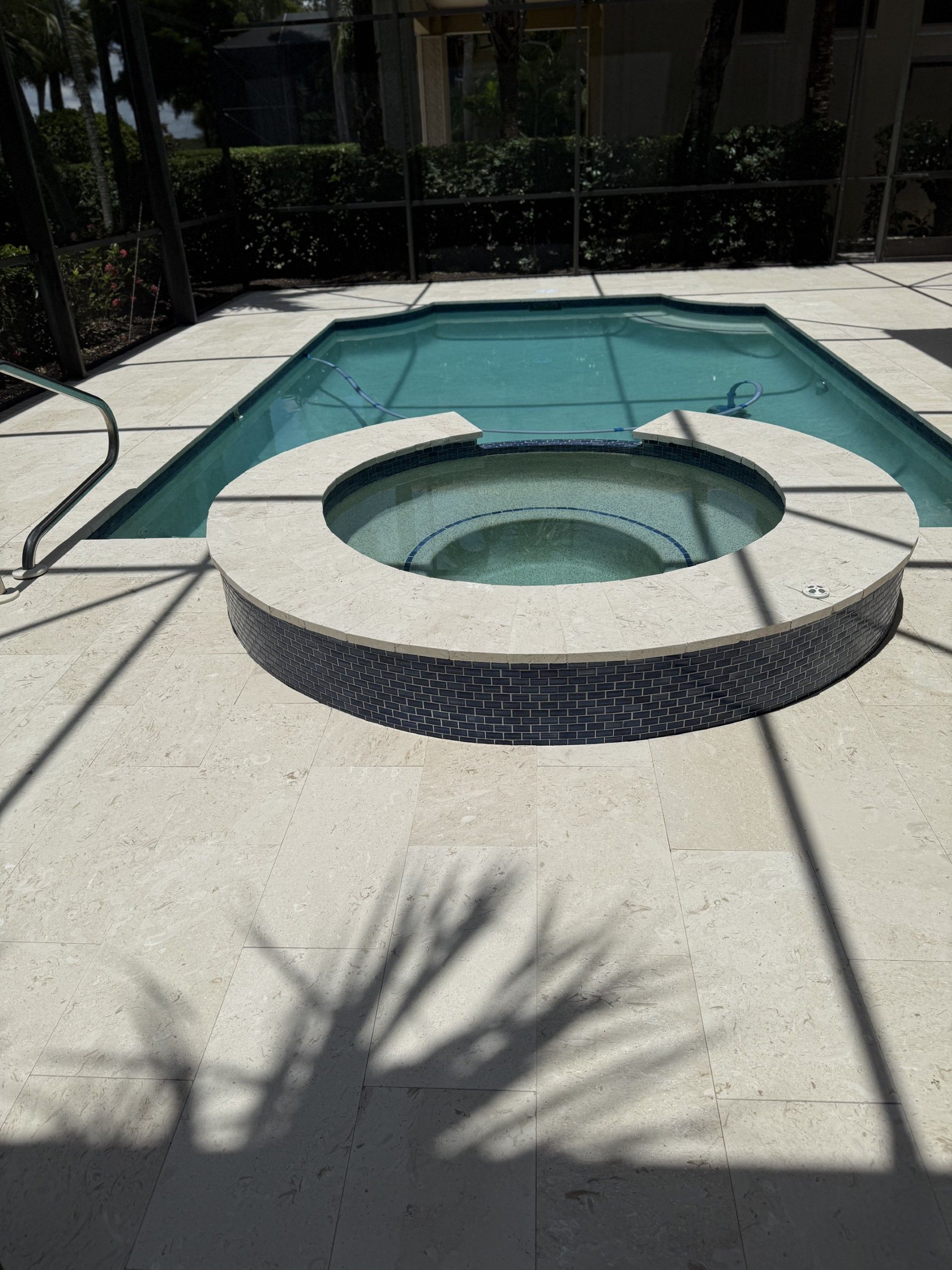 A large swimming pool with a hot tub in the middle.