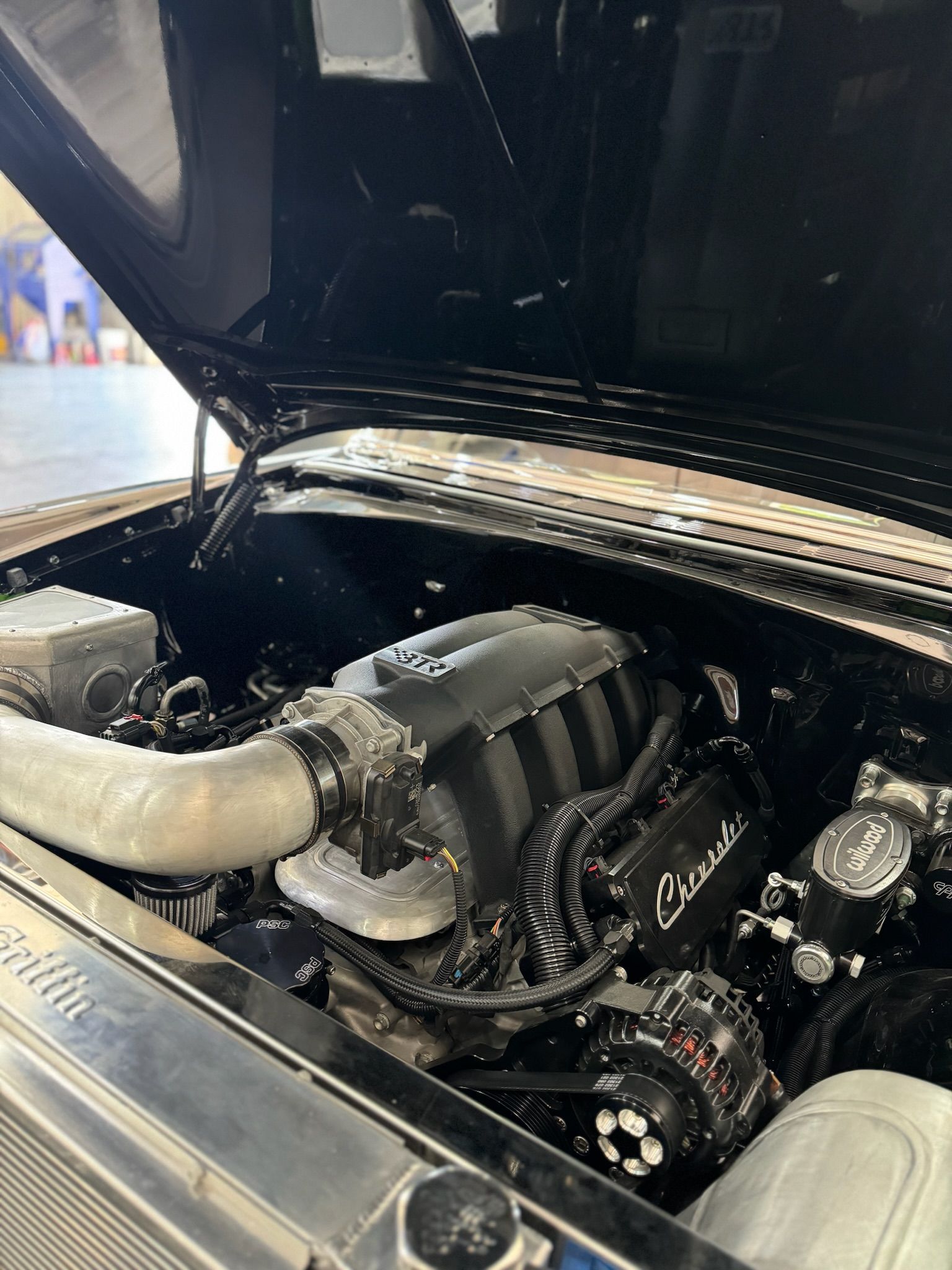 A close up of a car engine with the hood open.