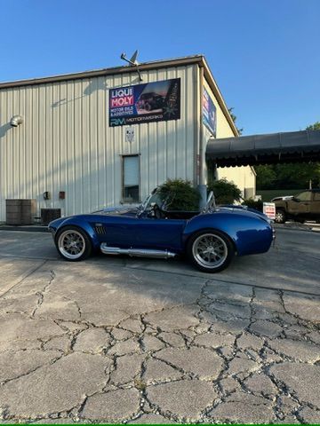 A blue sports car is parked in front of a building.