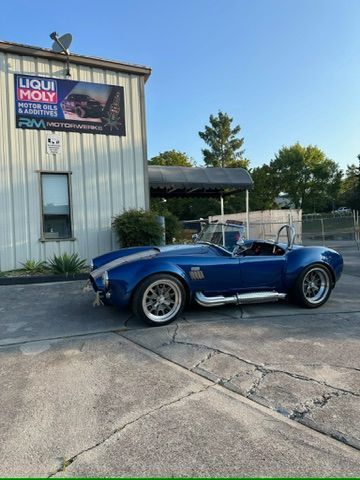 A blue car is parked in front of a liqui moly building