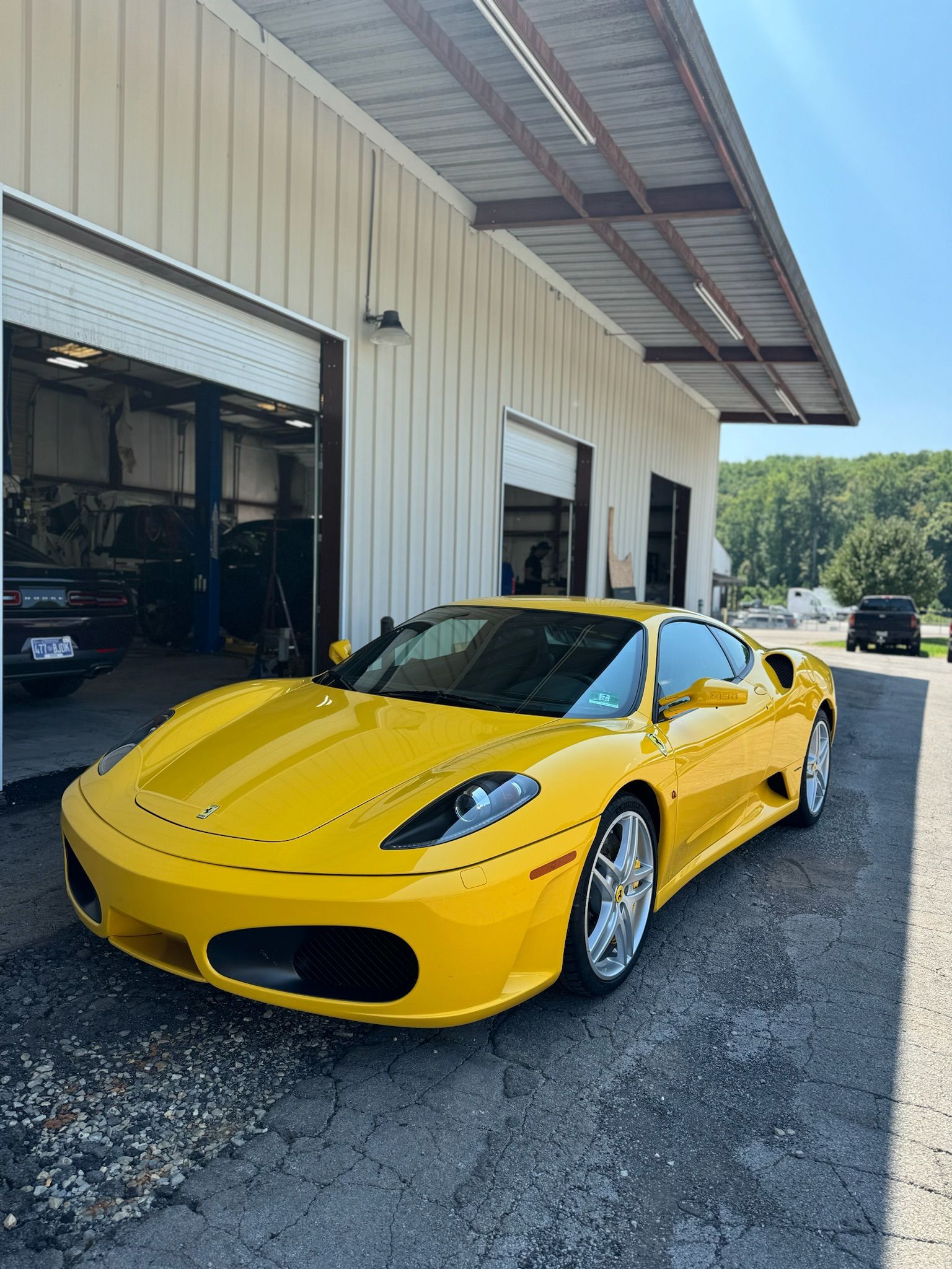 A yellow sports car is parked in front of a garage.