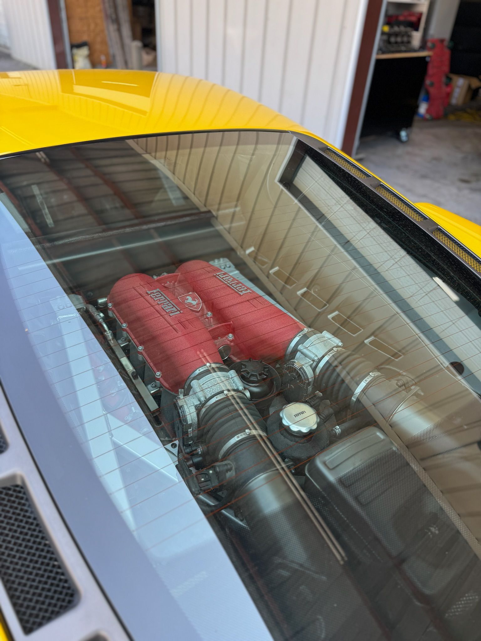 A close up of the engine of a yellow sports car.
