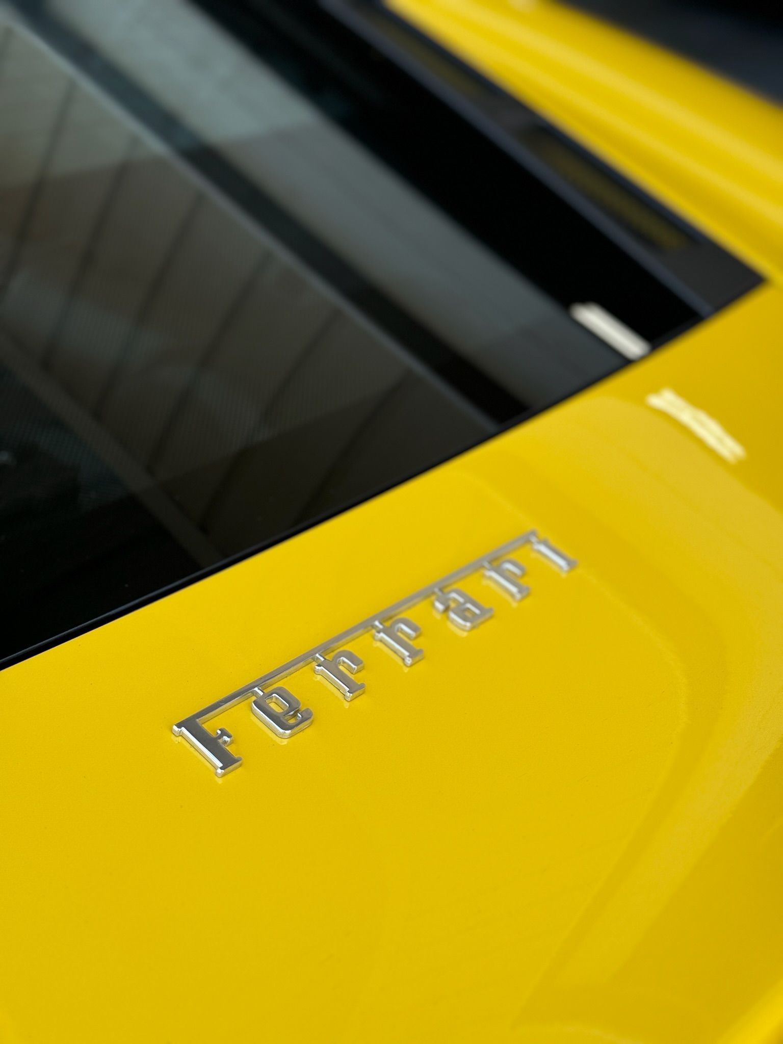 The word ferrari is on the side of a yellow car