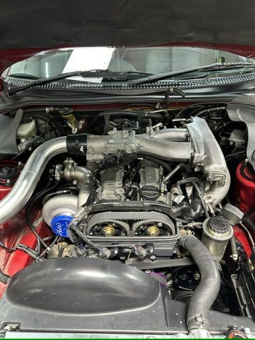 A close up of a car engine with the hood open.