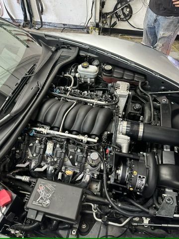 A close up of a car engine in a garage.