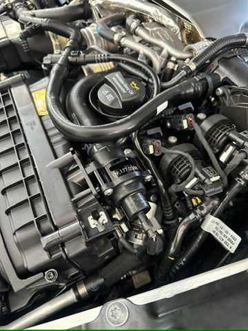 A close up of a car engine with a lot of wires coming out of it.