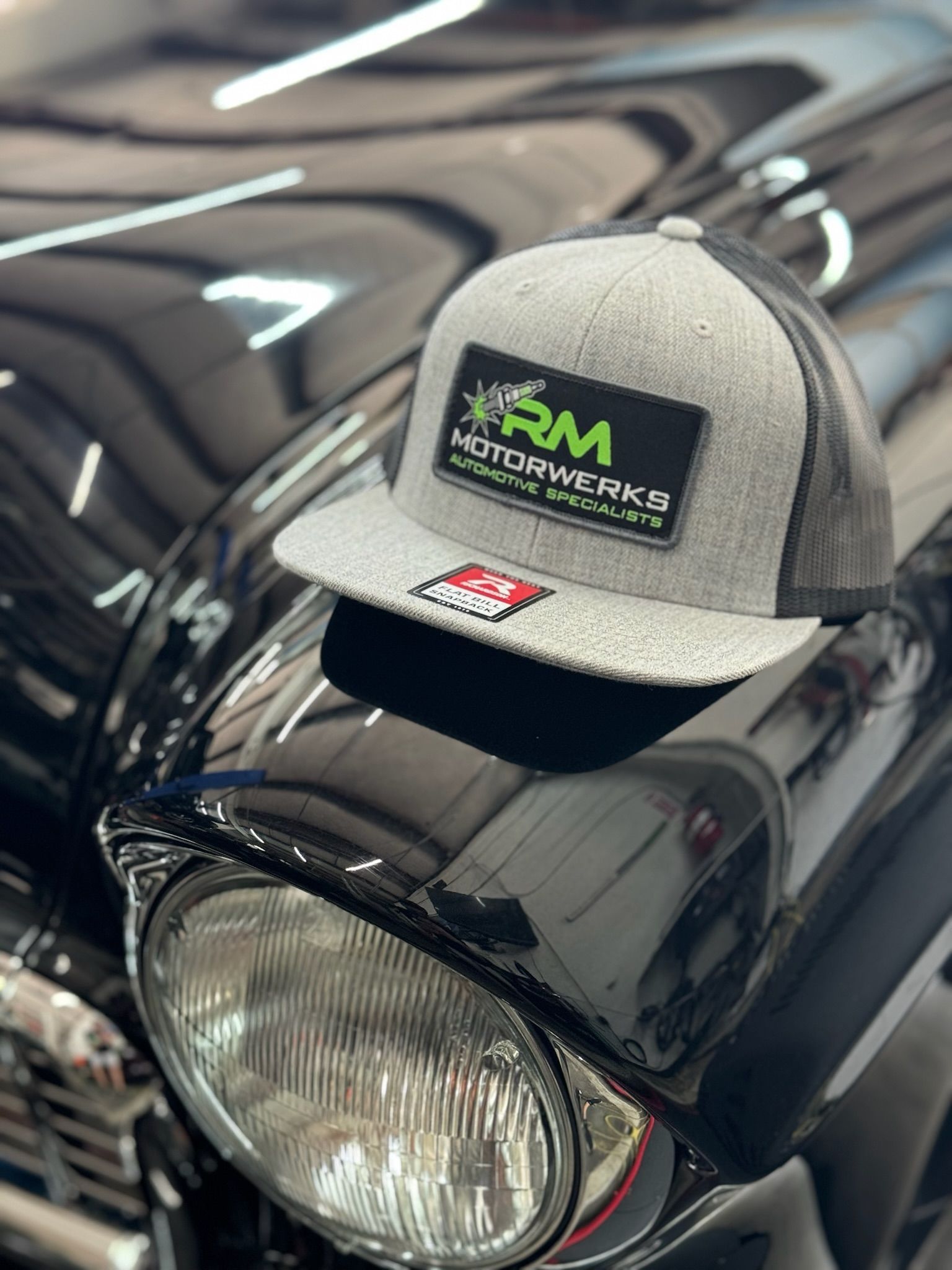 A hat is sitting on the hood of a motorcycle.