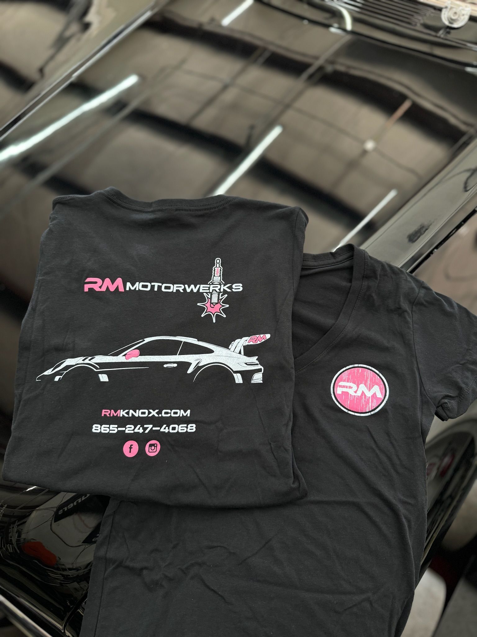 A black t-shirt is sitting on top of a black car.