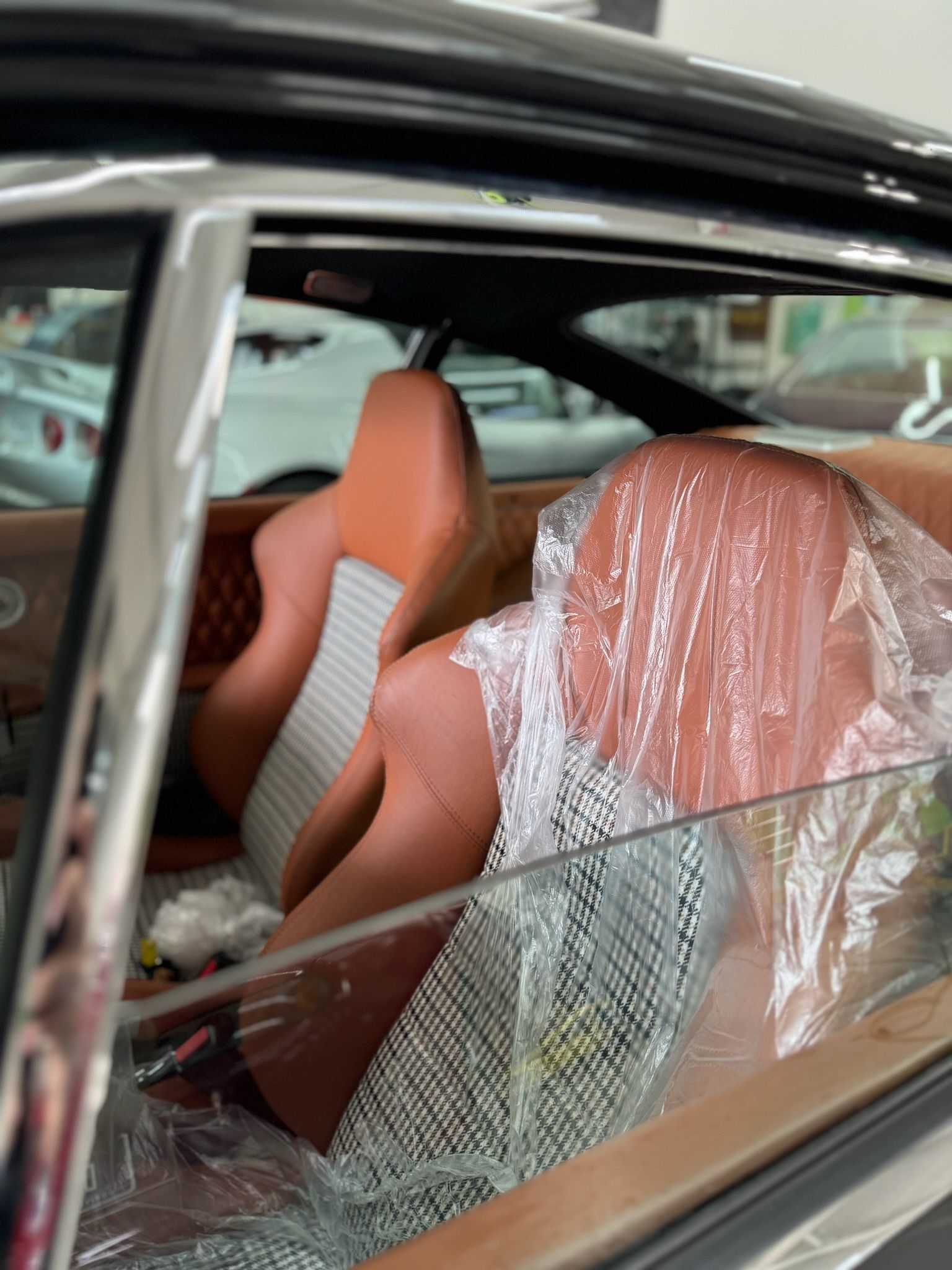 The seats of a car are wrapped in plastic.